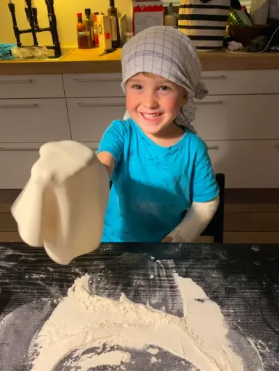 Et barn øver sig i at kaste pizzadejen