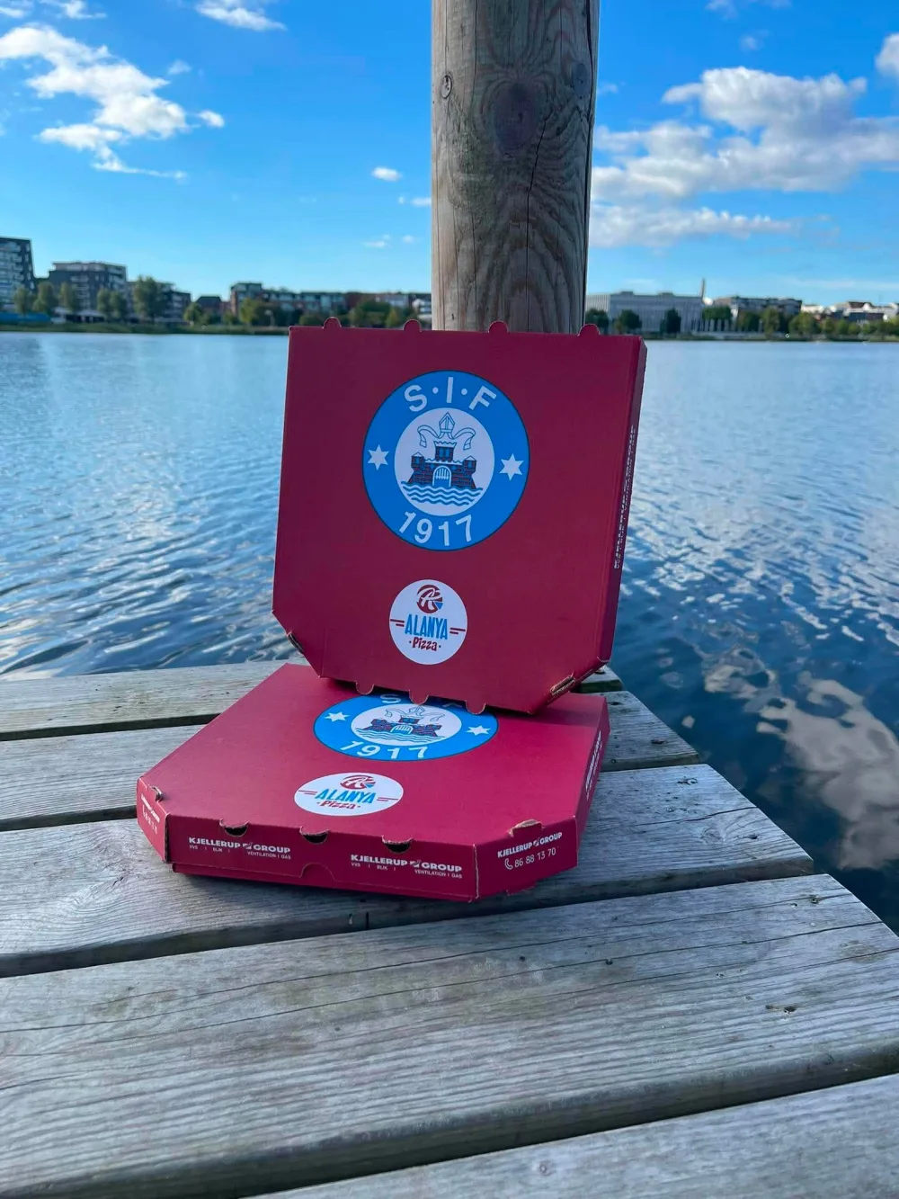 Alanya-pizzakasser med SIF-logo ved vandet i Silkeborg